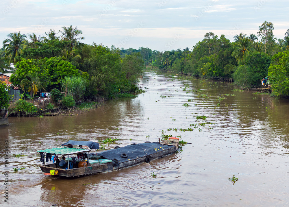 Wooden cargo boat on the Mekong River Delta Wooden cargo boat on the Mekong River Delta