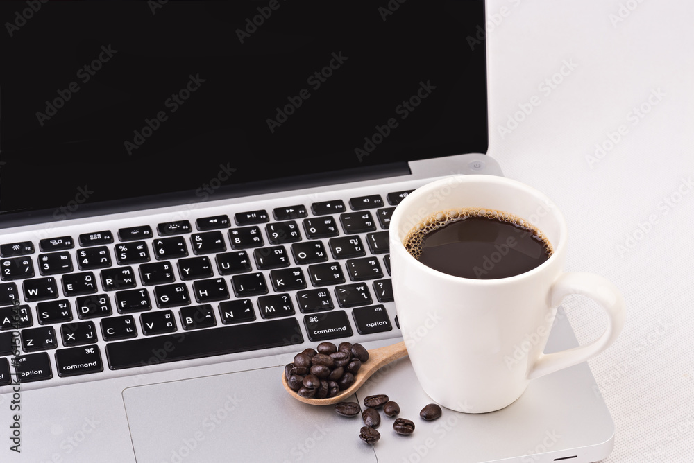 Coffee cup and beans turn on computer laptop on white background Coffee cup and beans turn on computer laptop on white background