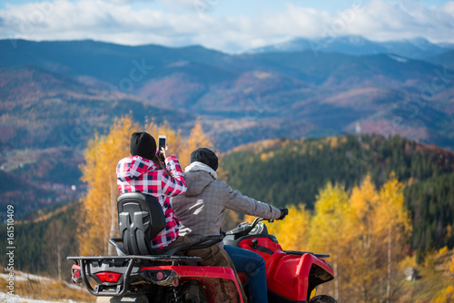 Canvas Print Close-up of male riding quadbike female sitting behind him makes photo of beauti