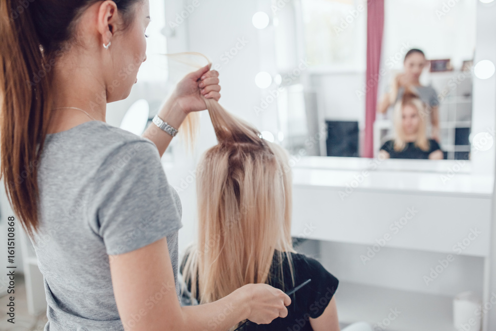 Hairdresser-stylist does the styling to the girl, using hair styling. Corrugated on the hair. Hairdresser-stylist does the styling to the girl, using hair styling. Corrugated on the hair.