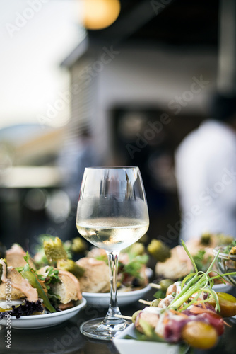 glass of white wine with gourmet food tapa snacks outside