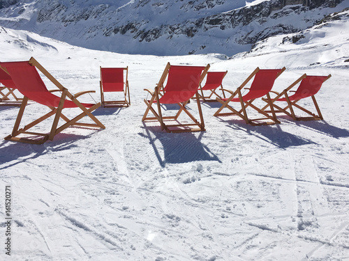 Winter sunbathing, deck chairs in the snow