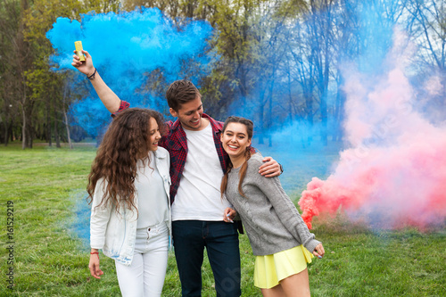 Friends with colored smoke on lawn