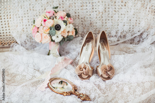 Luxury shoes and bride bouquet on the sofa
