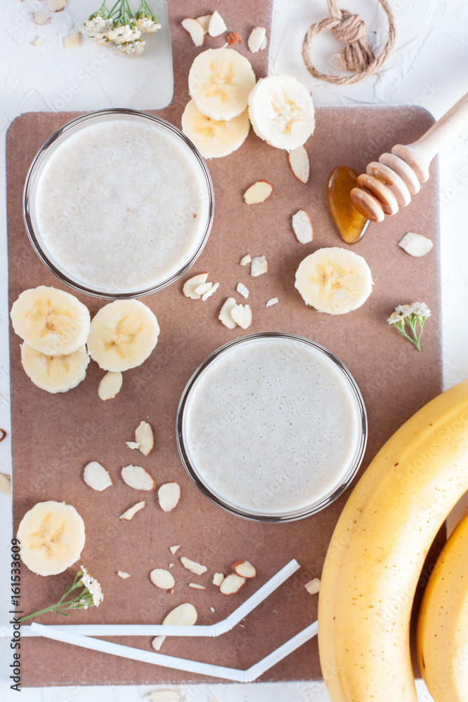 Milk cocktail with banana, almonds and honey, top view, selective focus Milk cocktail with banana, almonds and honey, top view, selective focus