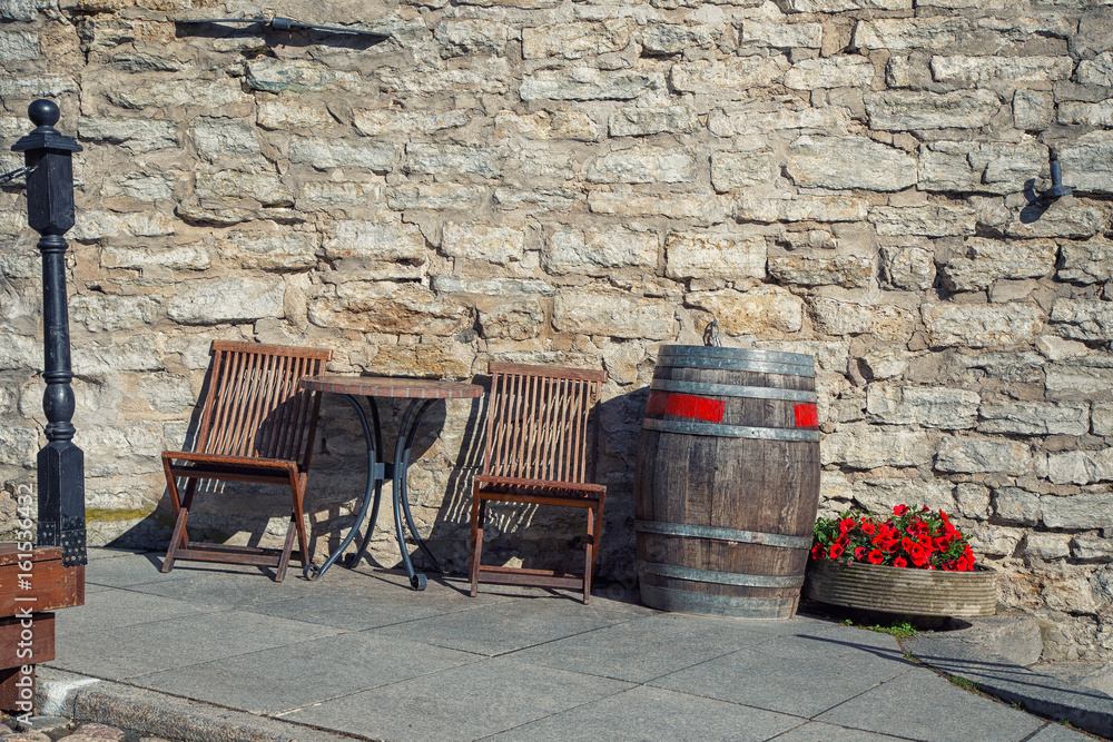 Naklejka premium Two empty chairs and a table in a cafe on a street in a European city