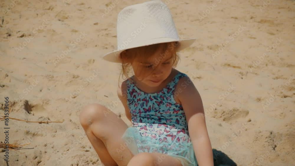 Little and lovely girl playing on the beach by the sea in summer Little and lovely girl playing on the beach by the sea in summer