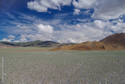 Mongolian Altai. Summer in mountains. Landscape. Arid landscape and mountains against the background of the unusual cloudy sky. Nature and travel. Mongolia