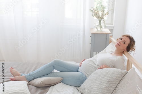 Pregnant woman lying on bed