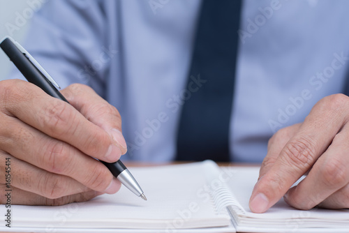 Businessman writing on notebook