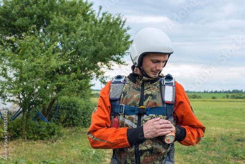 Portrait of resolute skydiver who checks his gear