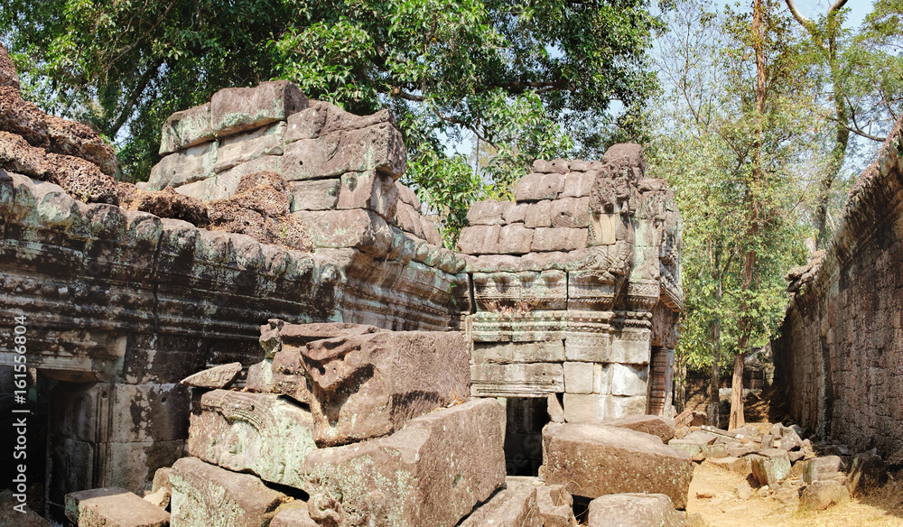 The ancient ruins of the Preah Khan Temple in Siem Reap, Cambodia. A pile of old stones on a tourist road in the foreground. Ancient Khmer architecture, famous Cambodian landmark, World Heritage