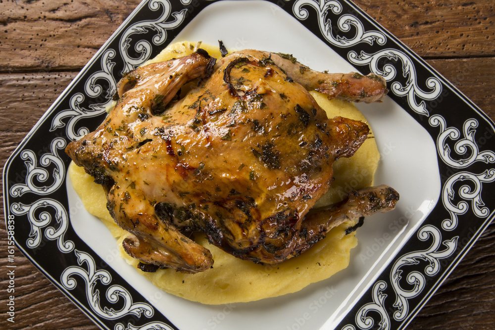Little Chicken dish with polenta on wood background Little Chicken dish with polenta on wood background