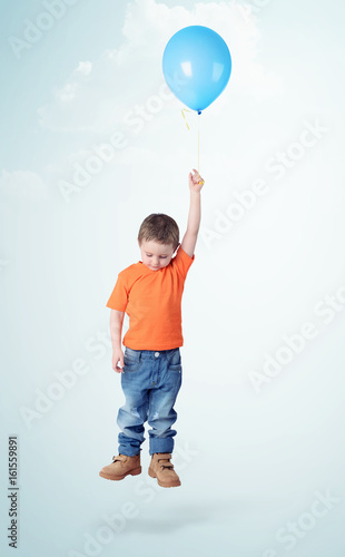 Little boy flies on blue balloon on light blue background © afxhome