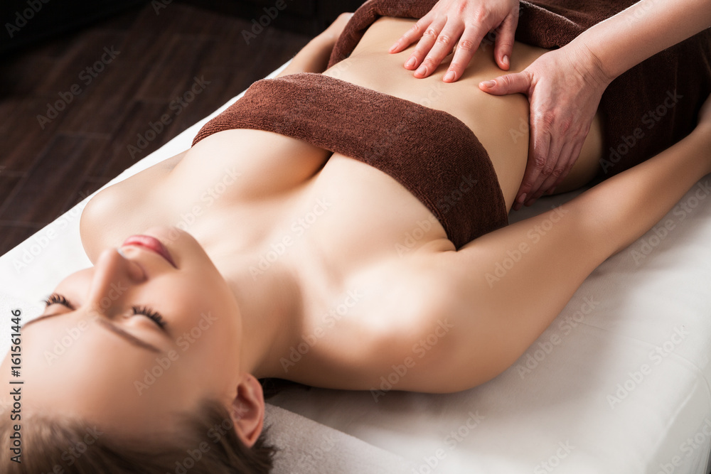 Obraz premium Woman enjoying a Ayurveda oil massage treatment in spa