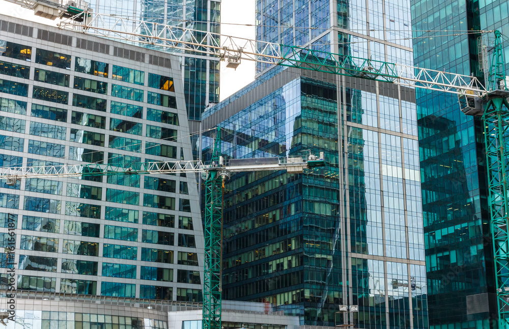 The construction of a skyscraper, a building of glass and concrete.
