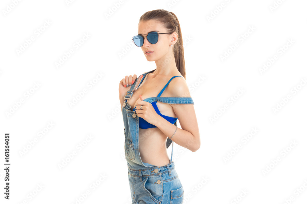 Fashionable lady with big natural boobs wears a jeans clothes and looks at the camera Fashionable lady with big natural boobs wears a jeans clothes and looks at the camera