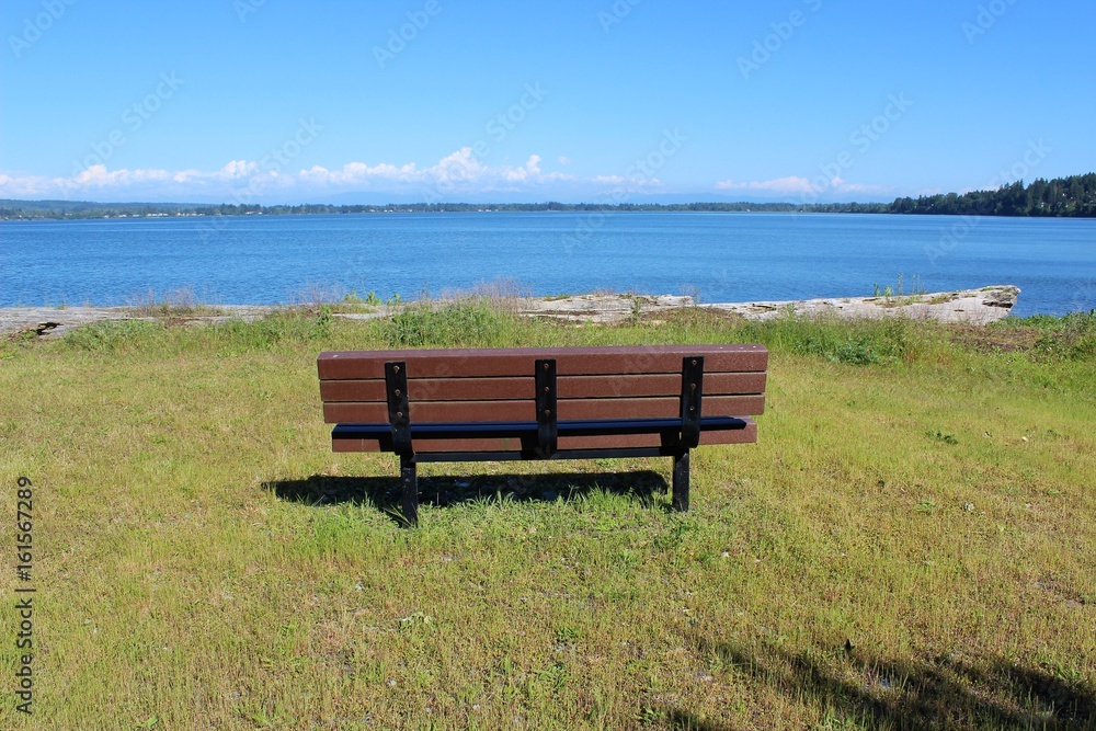 An empty bench with a beautiful bay view waiting for someone to sit and relax 