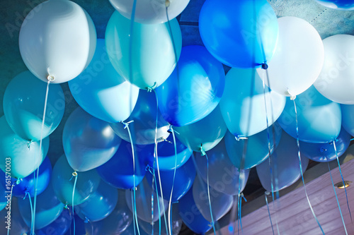 Festive decorated selling with blue tone helium balloons, birthday party