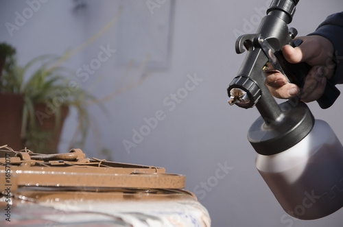 hombre pintando con pistola de pintura photo