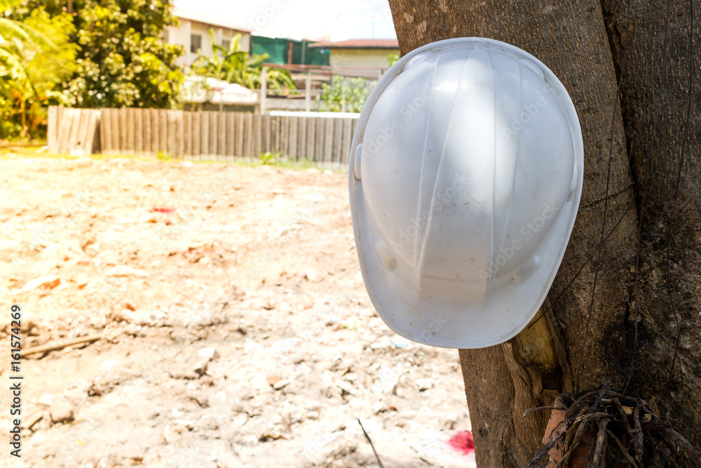Hat safety white color on tree in site construction Hat safety white color on tree in site construction