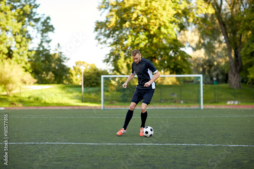 soccer player playing with ball on football field