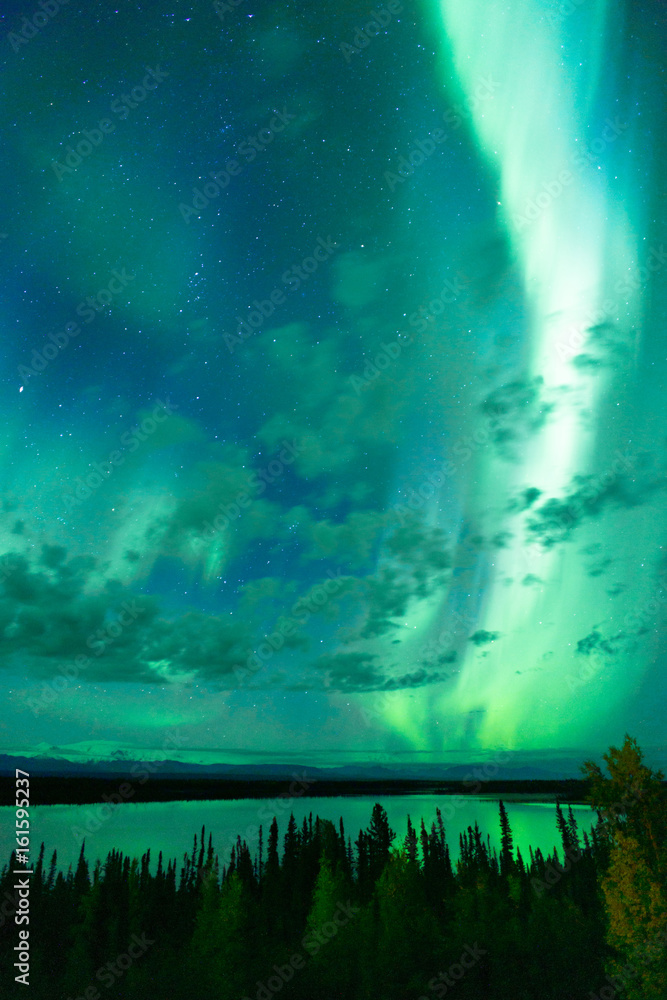 Lake Reflects Aurora Borealis Emerging Through Clouds Remote Alaska