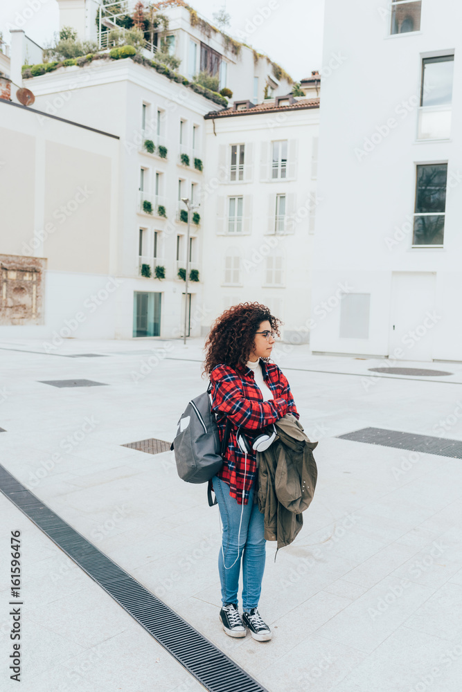 Young woman beautiful mixed race posing outdoor in the city looking away smiling - happiness, getting away from it all, independence concept