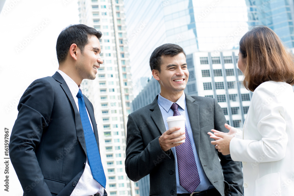 Group of business people talking outdoors on blur office building background in the city Group of business people talking outdoors on blur office building background in the city
