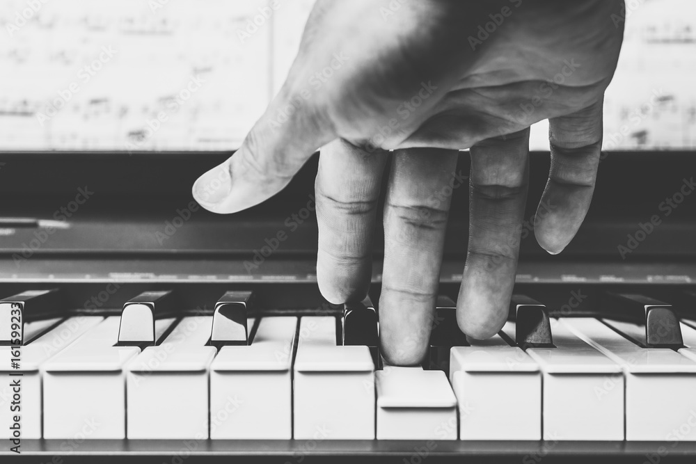 Fototapeta mężczyzna muzyk ręce gra na klawiszach fortepianu, czarno-biały