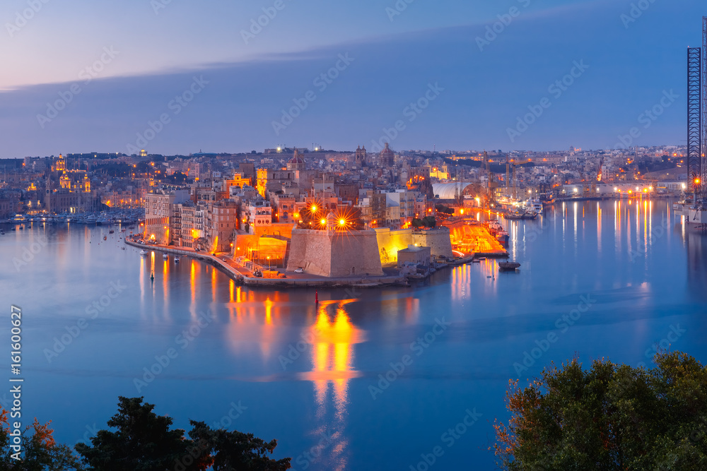 Skyline aerial view of ancient Fort Saint Michael of Senglea peninsula and the Grand Harbor as seen from Valletta during morning blue hour, Malta.