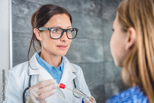 Female doctor taking a throat culture