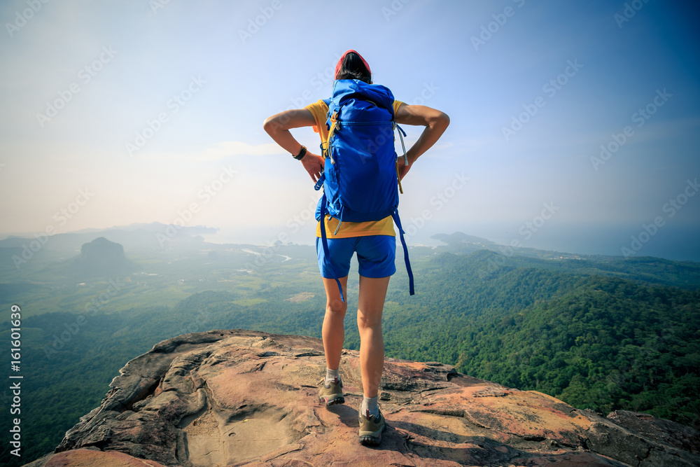 successful woman hiker hiking on mountain peak