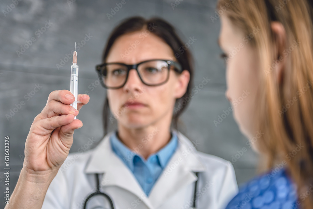 Doctor preparing a vaccine to inject into a patient Doctor preparing a vaccine to inject into a patient