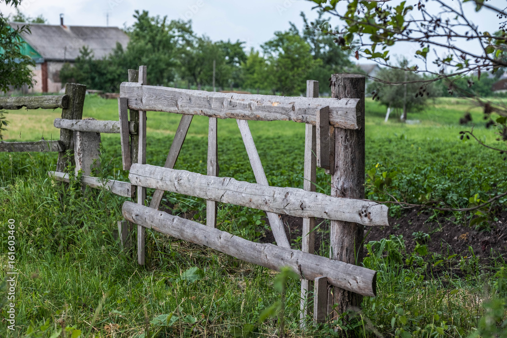  Wooden fence fields in a village in the summer overcast