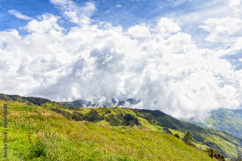 A green valley with dramatic clouds near Tolima, Colombia.