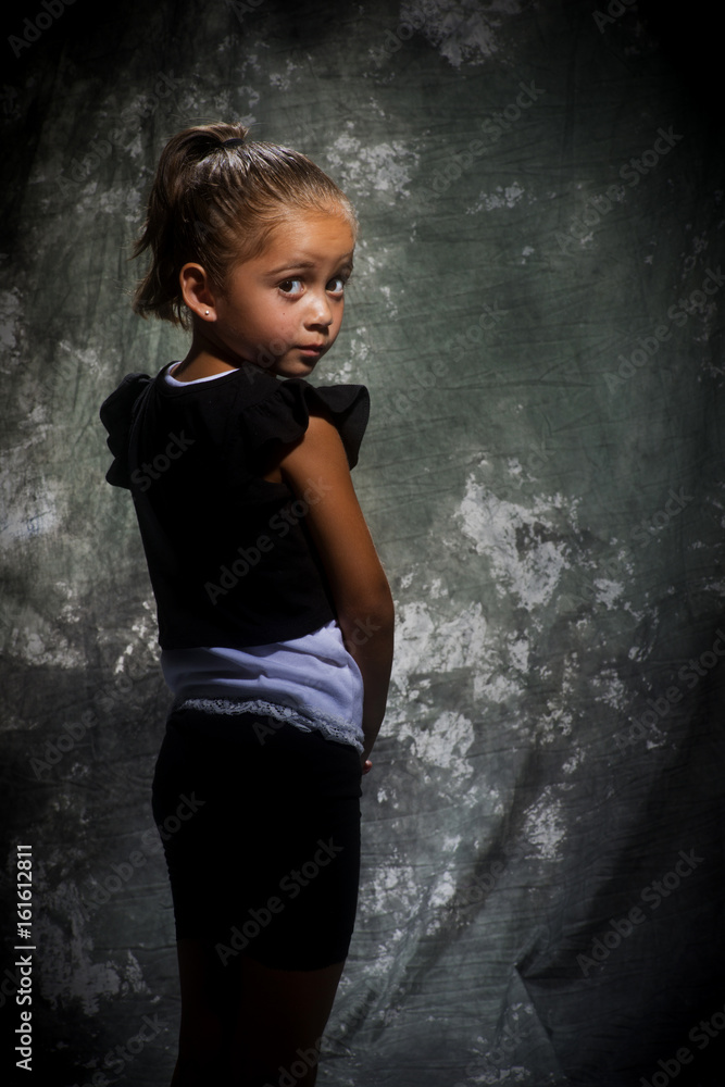 Fotografie girl posing in studio looking over shoulder