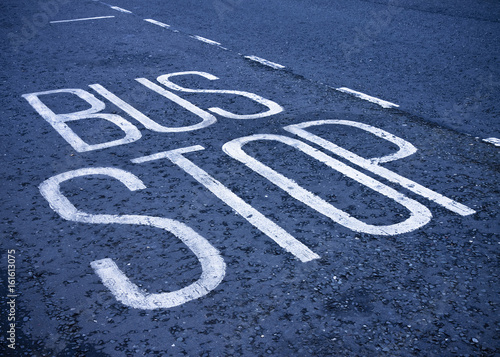 Bus Stop written on blue asphalt - concept image