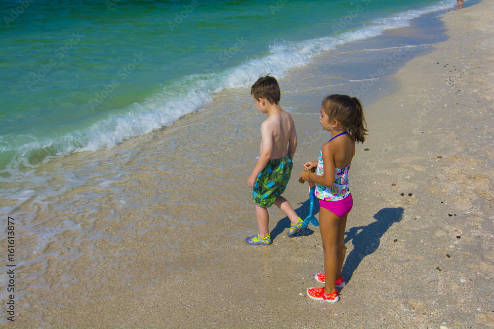 Εκτύπωση καμβά young girl and bot at the beach by the water playing togather in swim suits