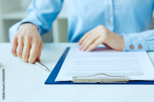 Hands of business woman signing the contract document with pen on desk. selective focus image on sign a contract.