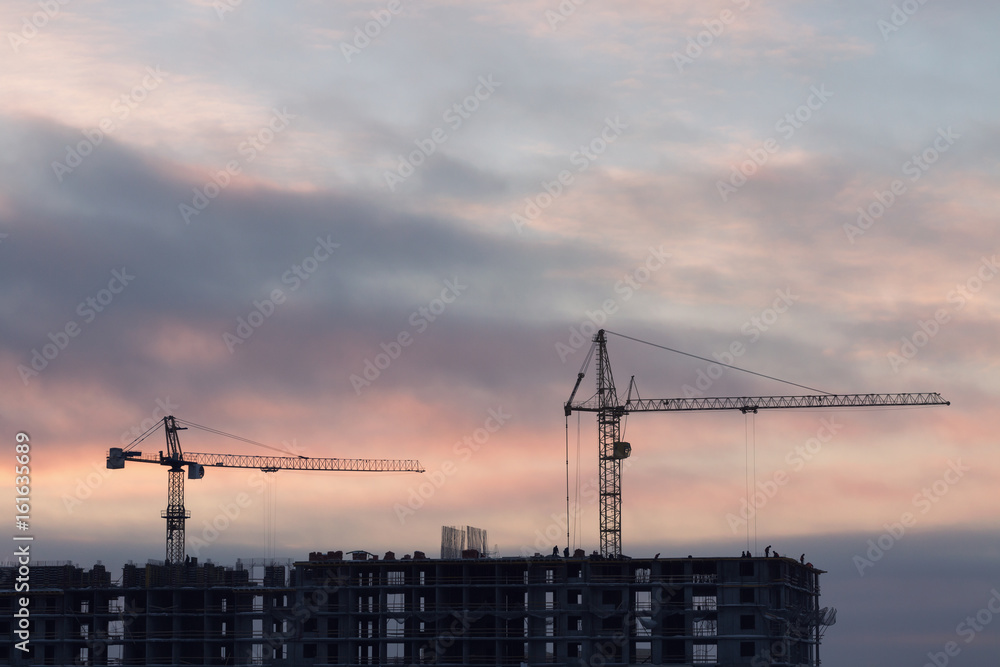 Construction site with cranes at sunset