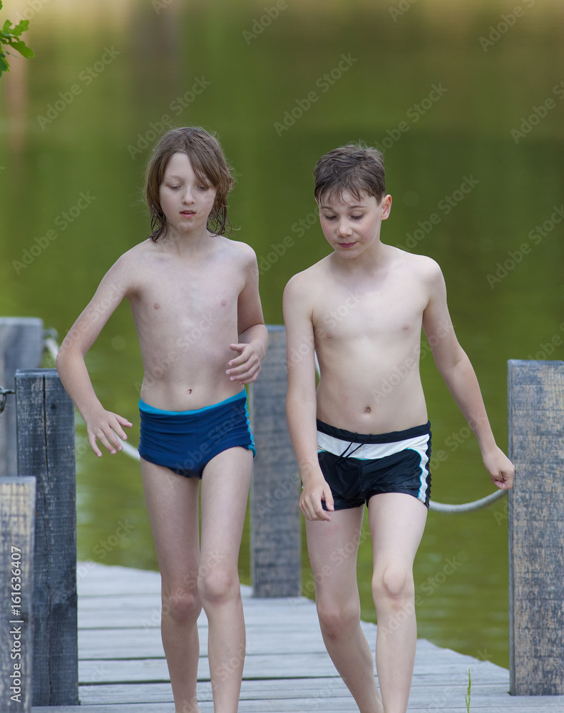 Obraz premium Two Boys Walking on Jetty