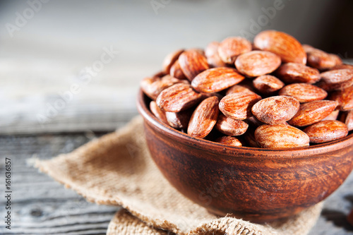 roasted almonds in bowl on wooden table photo