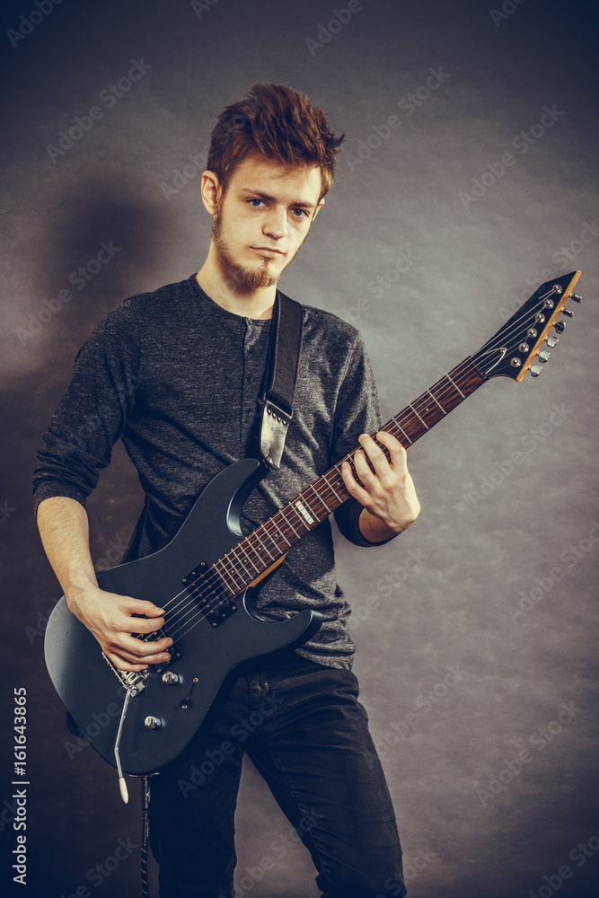 Obraz premium Young man playing electric guitar