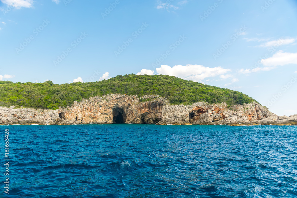 In the huge rocks there is the Blue Grotto with turquoise water. Montenegro.