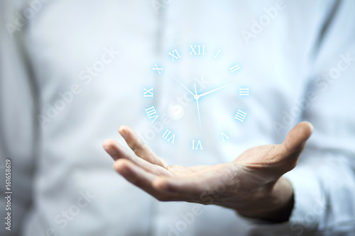 Business man hand holding clock in screen