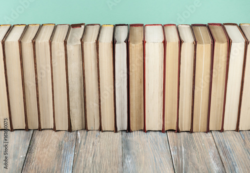 Stack of colorful books on wooden desk. Copy space for text. Back to school. Education background