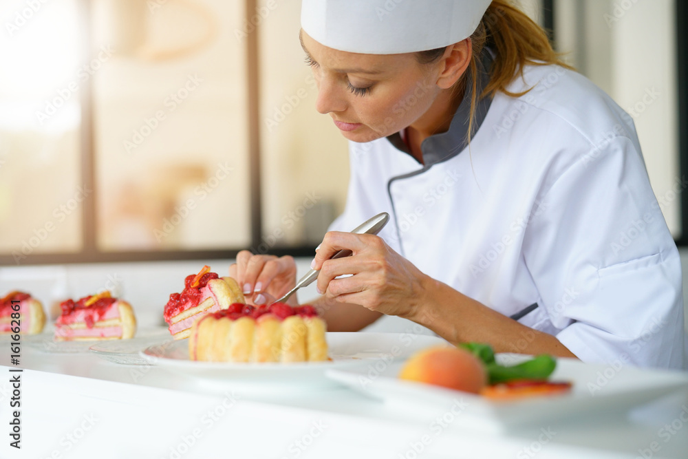 Portrait of pastry chef cutting slices of cake for serving Portrait of pastry chef cutting slices of cake for serving