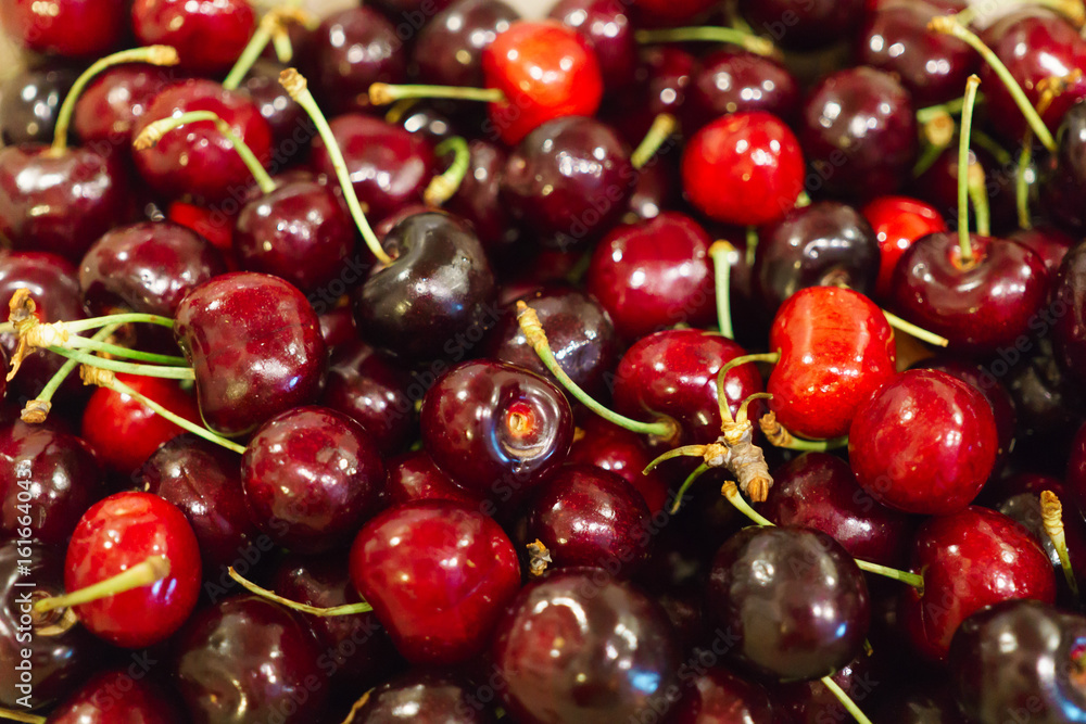 Fresh burgundy sweet cherry poured into a box. Fresh burgundy sweet cherry poured into a box.
