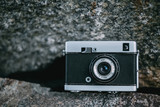 Old retro camera on gey stone abstract background soft focus